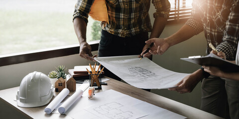 Team construction engineers working at construction site with blueprint on table
