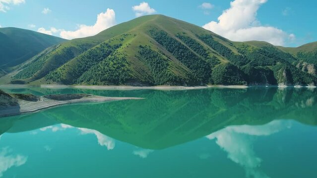 Aerial over lake Kezenoy-am with turquoise water and tall mountains around. Stunning scenery in highlands of Chechen Republic, Russia