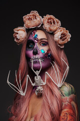 Studio shot of woman with bate skeleton and makeup in mexican muertos style.