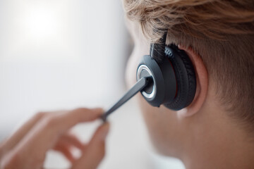 Closeup, headset in call center with woman, consultant or telemarketing in office. Contact us, crm...