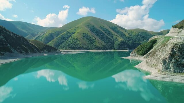 Aerial over lake Kezenoy-am with turquoise water and tall mountains around. Stunning scenery in highlands of Chechen Republic, Russia