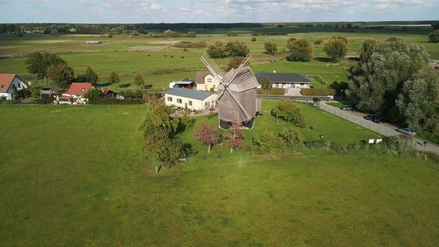 medieval architecture. Magic aerial view flight panorama orbit drone
of a old Wooden Trestle windmill in brandenburg Germany at summer golden hour 2022. 4k marnitz Cinematic