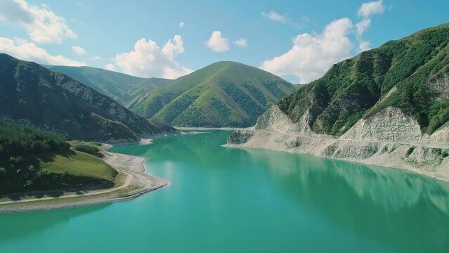 Aerial over lake Kezenoy-am with turquoise water and tall mountains around. Stunning scenery in highlands of Chechen Republic, Russia