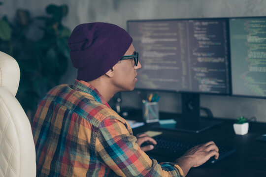 Photo of serious clever programmer wear spectacles hat writing code modern gadget indoors workplace workshop home