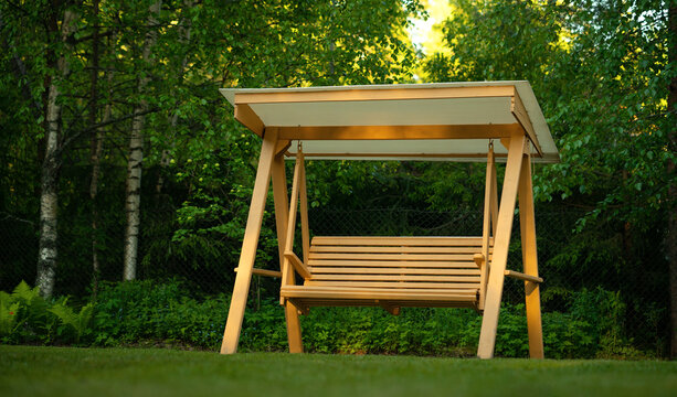 Garden triple wooden swing for the garden.Swing to the cottage with your own hands. Outdoor recreation in the garden.