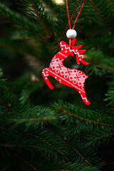 Wooden red white deer hanging on Christmas tree. Christmas wooden decoration.