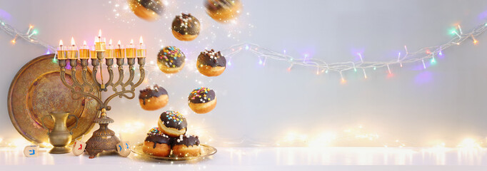 Image of jewish holiday Hanukkah background of menorah (traditional candelabra), doughnut and candles. Spinning tops with letters that mean, a great miracle happened here