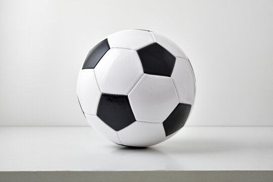 View of soccer ball on table and light gray background