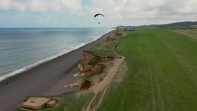 Parachute glider above the cliffs of sandy Weybourne beach in England
