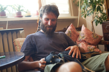 Cute love between a man and a dog; rastafarian dreadlocks man holding his dog, petting and hugging...