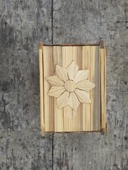 Indonesian bamboo art crafts. Homemade, Indonesian traditional bamboo. Handycraft, bamboo, mini tissue holder. Wooden background. Top view.