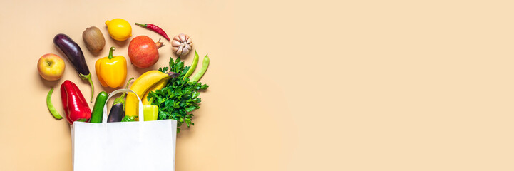 Eco friendly paper shop bag with raw organic green vegetables isolated on beige background Flat lay, top view Zero waste, plastic free concept Healthy clean eating diet and detox, agriculture concept