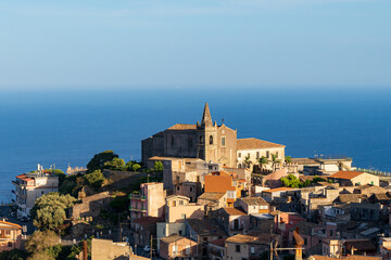 Obraz premium View of the Holy Trinity Church and the Augustinian Monastery. In the distance, the Mediterranean Sea and the cloudless sky. Sicily. Forze d 'Agro