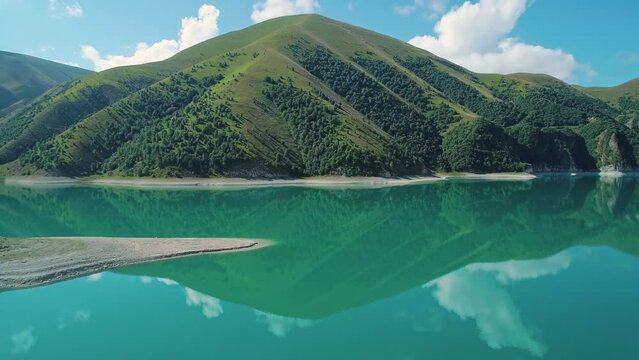 Aerial over lake Kezenoy-am with turquoise water and tall mountains around. Stunning scenery in highlands of Chechen Republic, Russia