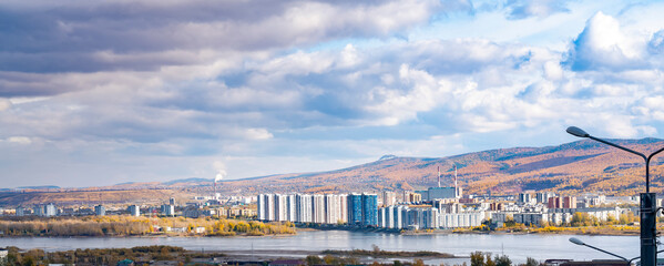 Fototapeta na wymiar Panorama of an industrial city against a cloudy sky.