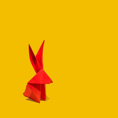 Creative greeting card design made of red paper rabbit on a vibrant yellow background. Lunar,...