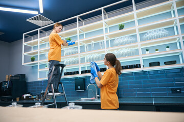 Female employees cleaning company carry out general cleaning in kitchen area