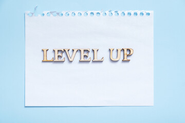 Level up inscription on the sheet note paper. Business and achievement concept