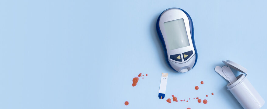 Banner with top vie glucose meter and blood drops on a blue background. Diabetes test concept