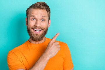 Portrait of astonished cheerful person beaming smile direct finger empty space isolated on teal...