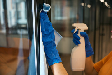 Employee cleaning service uses spray and napkin for washing and disinfecting