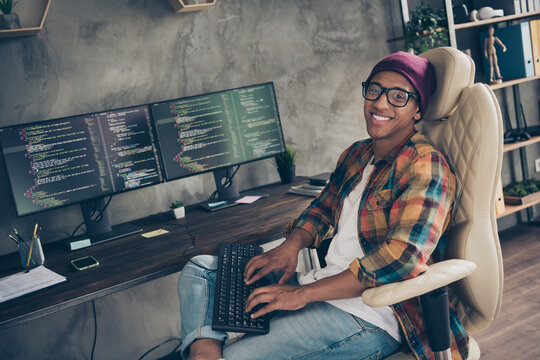 Photo of smiling happy guy dressed eyewear hat chatting modern device indoors workstation workshop home