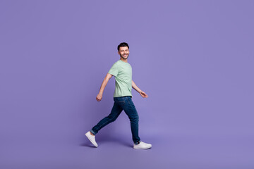 Full length profile side photo of satisfied man trendy clothes move empty space promenade good mood isolated on purple color background
