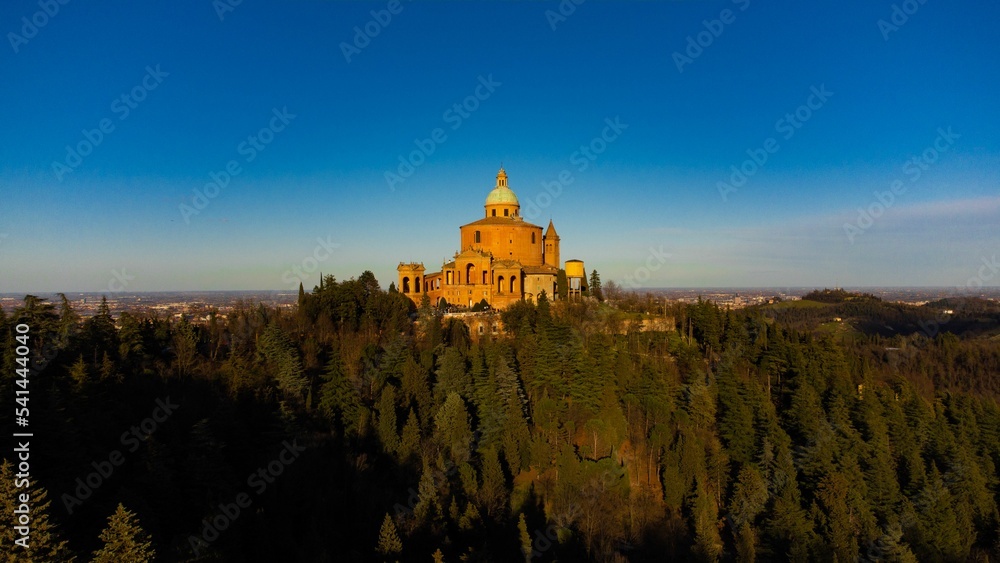 Wall mural Aerial view of San luca chuch surrounded by dense trees in Italy