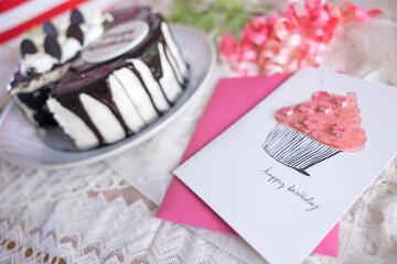 ピンクの誕生日メッセージカードと誕生日ケーキ