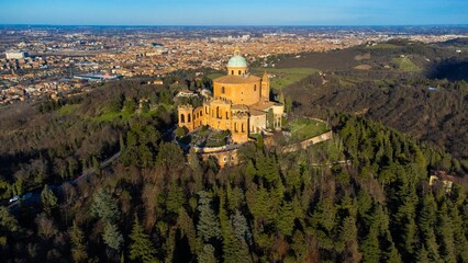 Aerial view of San luca chuch surrounded by dense trees in Italy