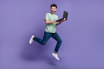 Fototapeta na wymiar Full length photo of positive man buy modern quality gadget device apple macbook move go empty space isolated on purple color background