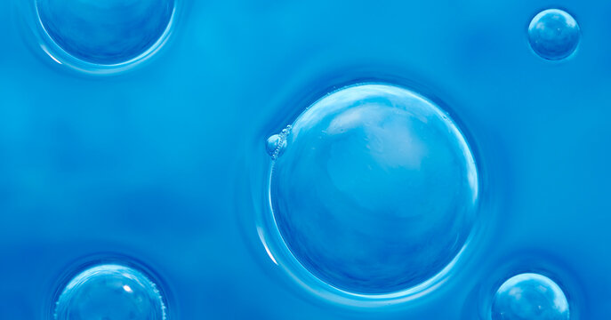 Close up of blue clear liquid surface texture with bubbles. Abstract banner with cosmetic gel bubbles