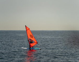 Isolated unrecognizable windsurfer in the middle of the ocean