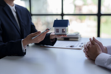 Real estate agent and clients are negotiating prices and previewing homes before signing and...
