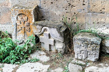 Armenia, Tatev, September 2022. Stone slabs with crosses near the church wall.