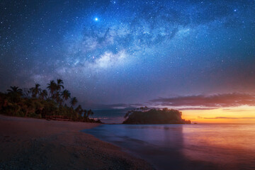Beautiful night view of beach with lonely island against background of blue starry sky and sunset