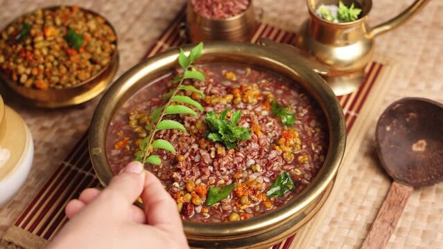 Ayurvedic porridge, Karkidaka Kanji herbal gruel in clay pot red rice soup Kerala South India. Ayurveda diet health drink for immunity, cleanse the body. Top view medicinal porridge Indian veg food