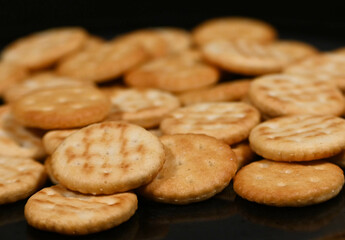 Fondo con detalle y textura de multitud de pequeñas galletas saladas sobre fondo de color negro