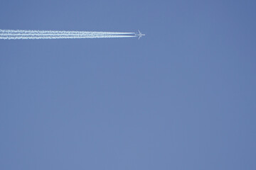 plane with white trail in clear sky. From the left. aviation in the sky with copy space