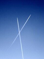 Flugzeug mit Kondensstreifen hoch am Himmel