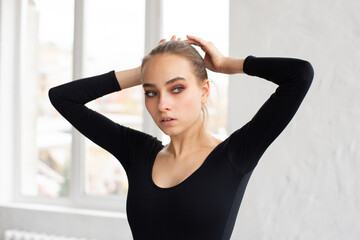 Modern female dancer in black outfit practices in a dance studio