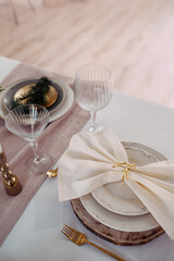 Plates served with elegant napkins with a golden clip in the shape of a deer.