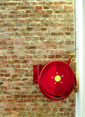 Red fire hydrant on the brick, old wall