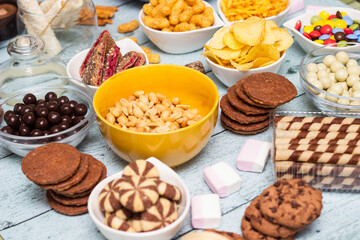 Salty and sweet snacks. Table of salty and sweet snacks. Large group of unhealthy food