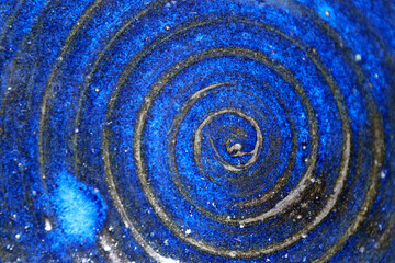 Platter with a swirling design, vividly baked with a cobalt blue glaze. Pottery texture.