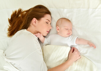 Young mother and her baby, sleeping in bed. Mother and baby. Happy family. - 541461214