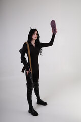 Agressive young woman with assault rifle and dangerous slipper