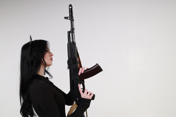 Slender glamour young woman with assault rifle