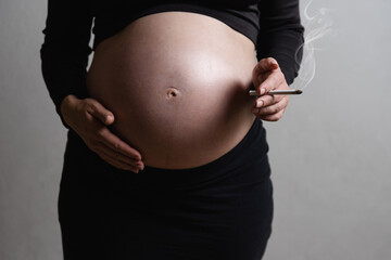A pregnant woman smokes cigarettes. the concept of the harm of smoking during pregnancy