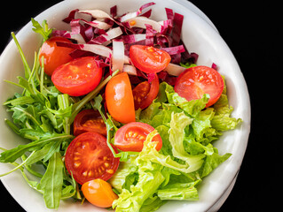 Mixed salad with lettuce,tomato and fresh rucola leaves. vegetarian dish